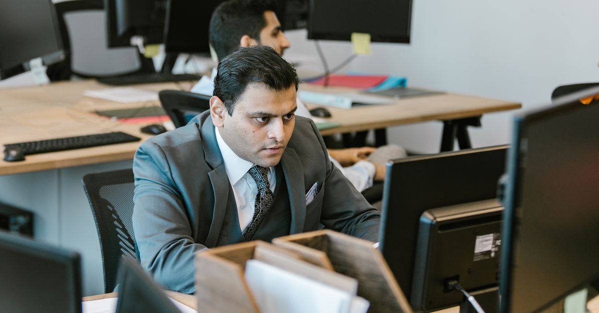 Focused person in front of a computer in a bright, modern workspace