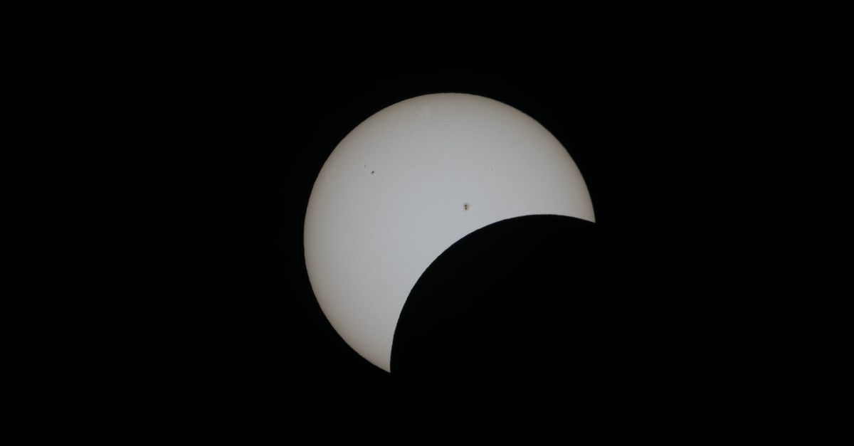 Observers facing the setting Sun during an eclipse above a clear horizon