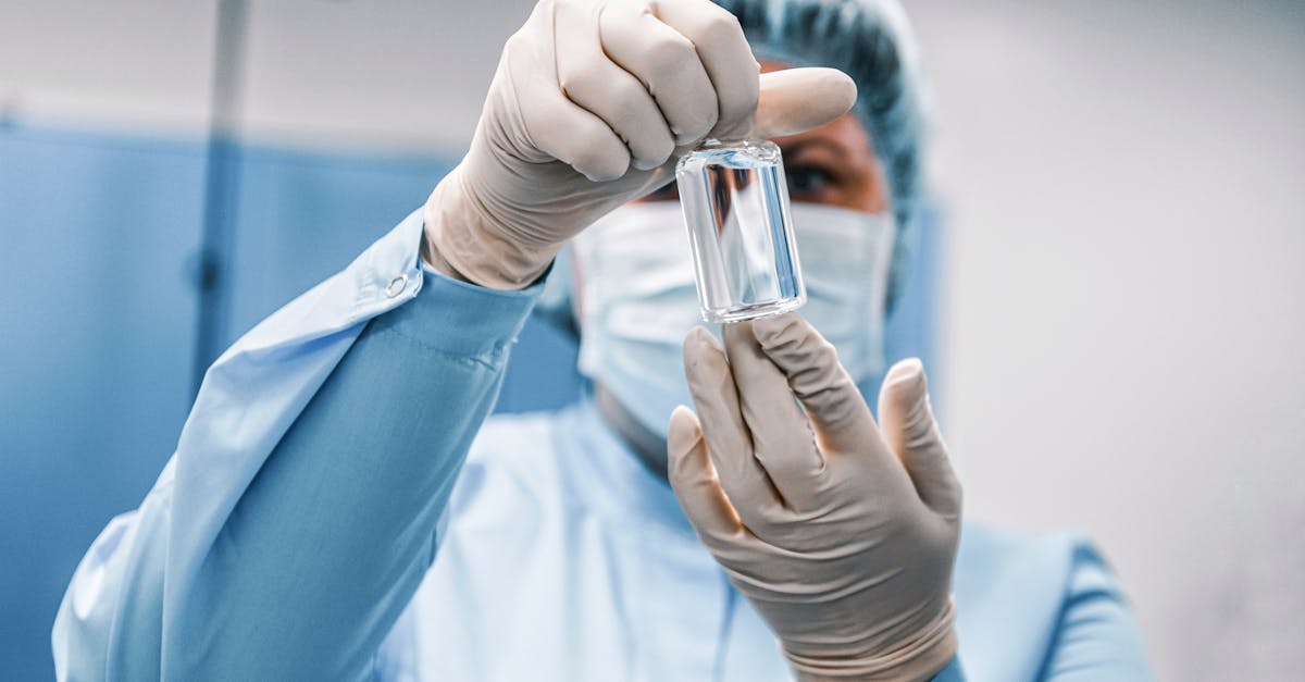 Laboratory researcher holding a syringe in front of digital scientific data on a screen