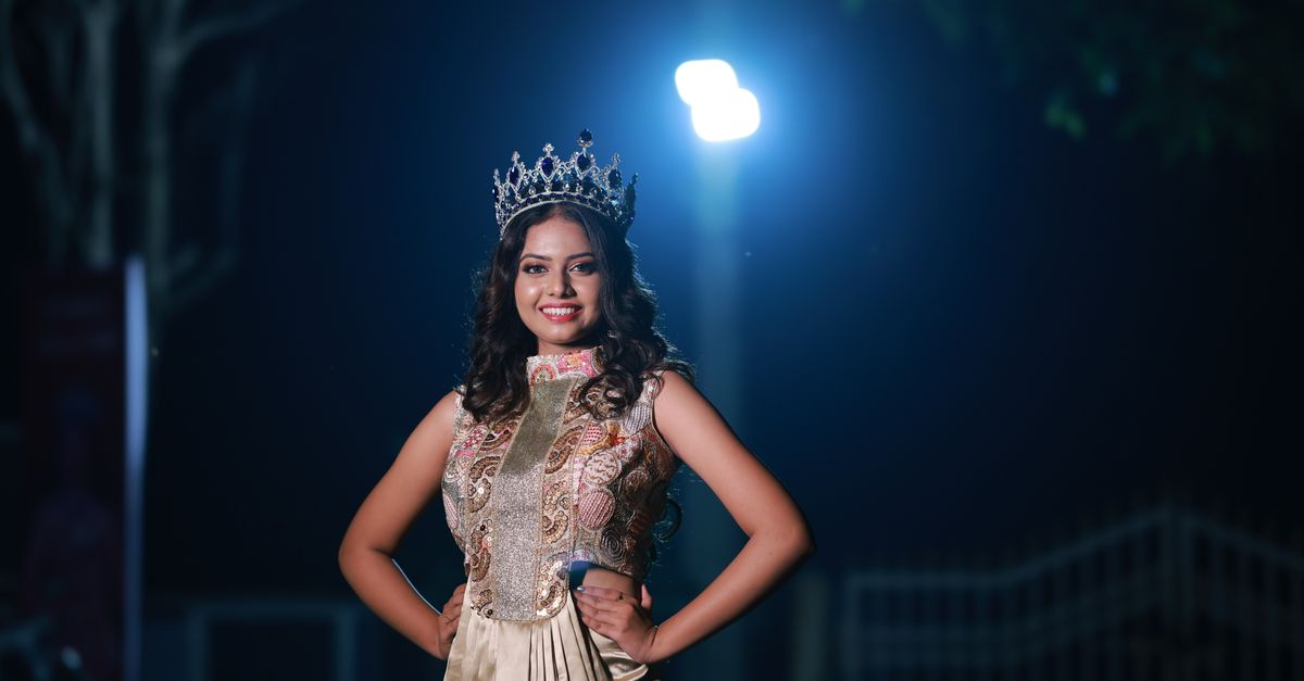Beauty pageant crown near spotlights in an empty performance hall