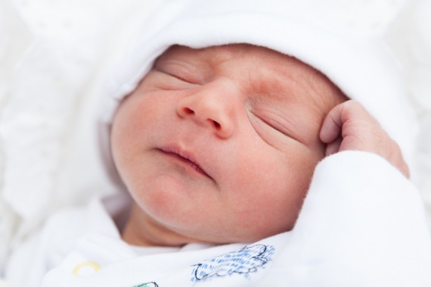 A baby sleeping peacefully on an inclined mattress designed to relieve gastroesophageal reflux symptoms
